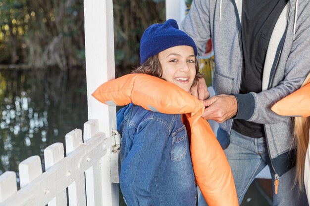 Glückliches Kind mit Jeansjacke und Schwimmweste