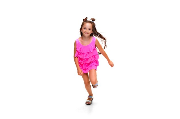 Glückliches kleines kaukasisches Mädchen, das isoliert auf weiß springt und läuft