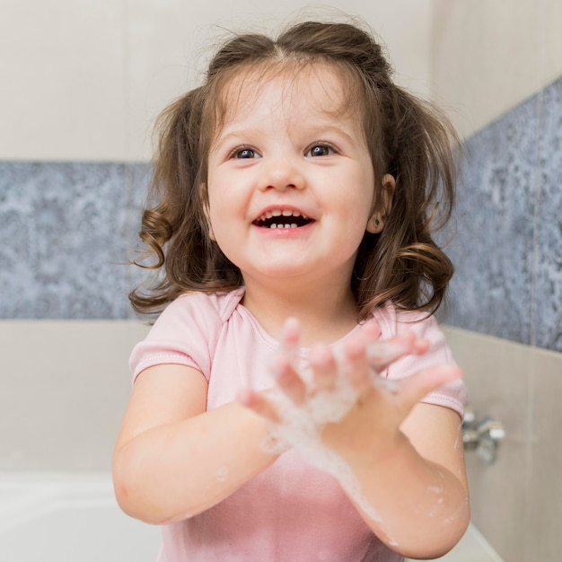 Glückliches kleines Mädchen, das Hände wäscht
