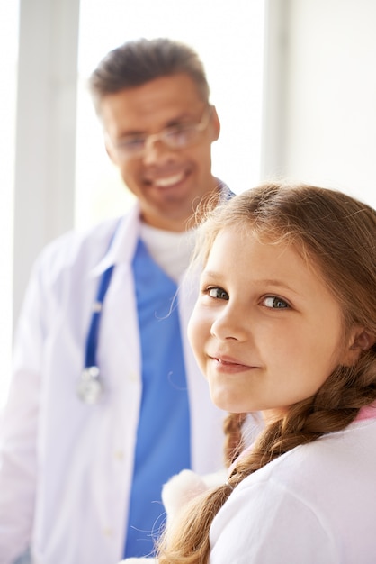 Glückliches kleines Mädchen mit einem Arzt
