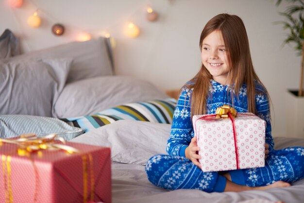 Glückliches kleines Mädchen mit Weihnachtsgeschenk