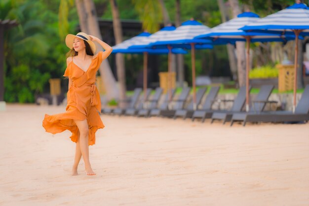 Glückliches Lächeln der schönen jungen asiatischen Frau des Porträts entspannen sich auf dem Strandseeozean