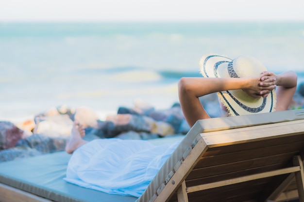 Kostenloses Foto glückliches lächeln der schönen jungen asiatischen frau des porträts entspannen sich um neary strand und meer