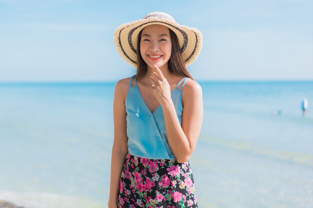 Glückliches Lächeln der schönen jungen asiatischen Frau des Porträts entspannen sich um Strandozean und -meer