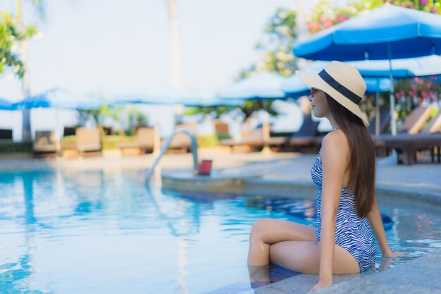 Glückliches Lächeln der schönen jungen asiatischen Frauen des Porträts entspannen sich Swimmingpool im Freien im Erholungsort