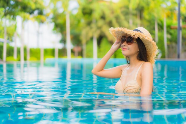 Glückliches Lächeln der schönen jungen asiatischen Frauen des Porträts entspannen sich Swimmingpool im Freien im Erholungsort