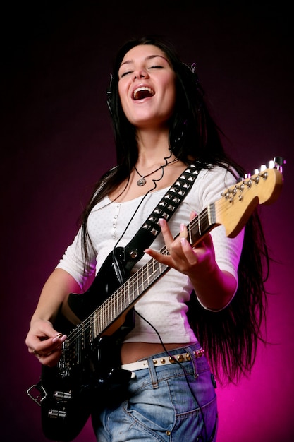 Glückliches lächelndes Mädchen, das Gitarre spielt