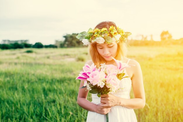 Glückliches Mädchen auf ihr Bouquet suchen bei Sonnenuntergang