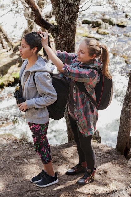 Kostenloses Foto glückliches mädchen, das die haare ihres freundes platziert