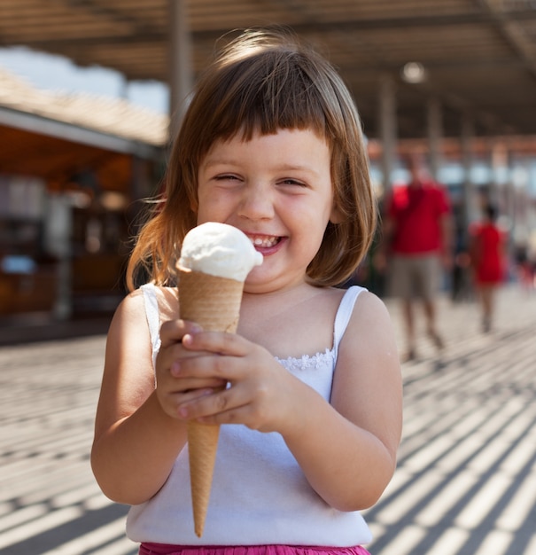 Glückliches Mädchen, das Eiscreme isst