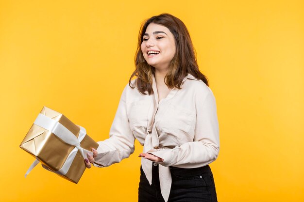 Glückliches Mädchen, das Geschenkbox hält und lacht Foto in hoher Qualität