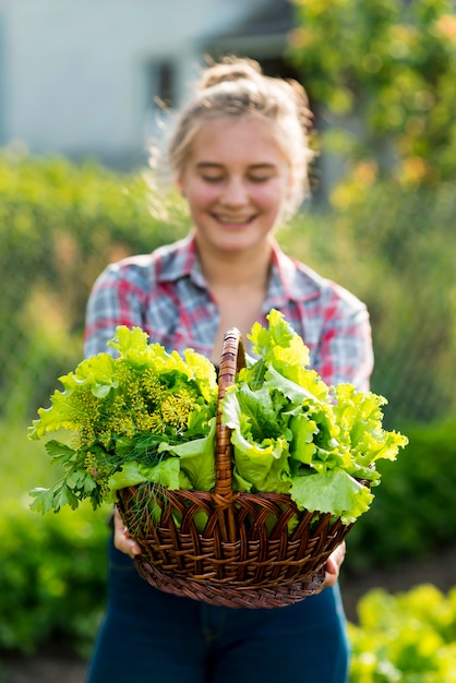 Glückliches Mädchen, das Salatkorb hält