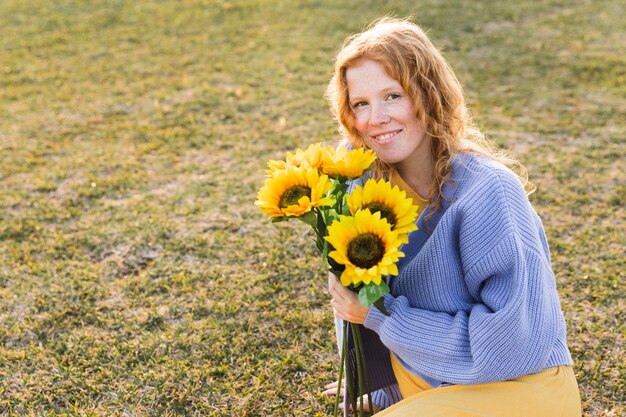 Glückliches Mädchen, das Sonnenblumen hält