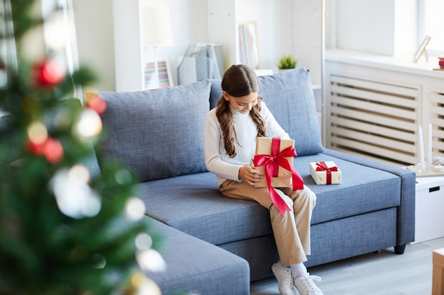 Glückliches Mädchen, das Weihnachtsgeschenke öffnet