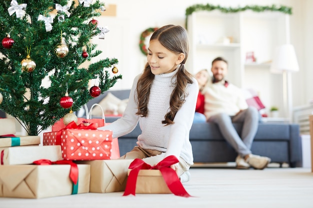 Glückliches mädchen, das weihnachtsgeschenke öffnet