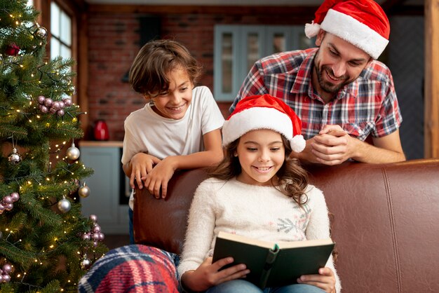 Glückliches Mädchen des mittleren Schusses auf der Couch mit Buch