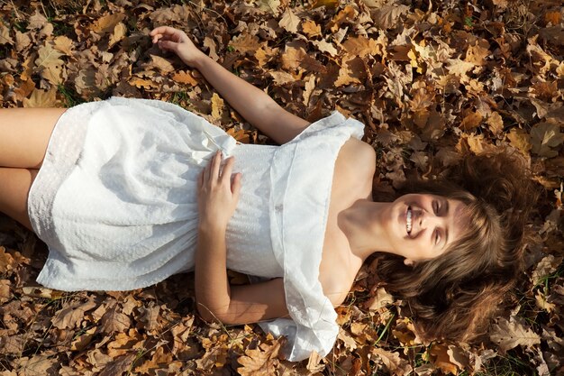 Glückliches Mädchen liegt im Herbst Park