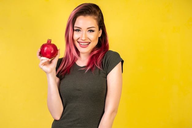 Kostenloses Foto glückliches mädchen mit granatapfel in den händen