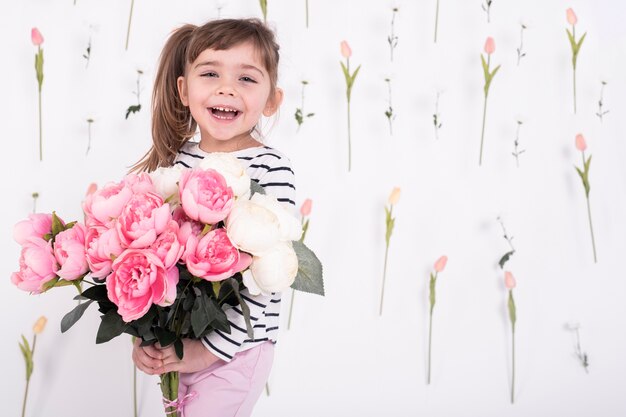 Glückliches Mädchen mit schönem rosafarbenem Blumenstrauß