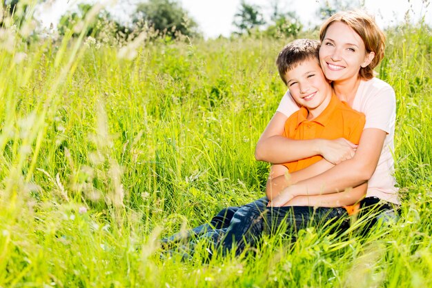 Glückliches Mutter- und Sohn im Außenporträt der Frühlingswiese