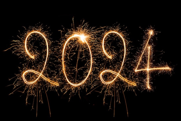 Kostenloses Foto glückliches neujahr 2024 funkelnd brennender text glückliches neuwahr 2024 isoliert auf schwarzem hintergrund