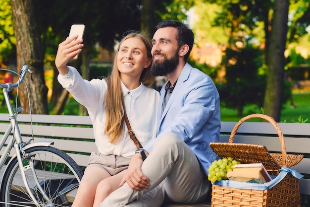 Glückliches Paar auf einem Picknick macht Selfie.