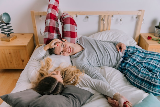 Glückliches Paar, das auf Bett stillsteht