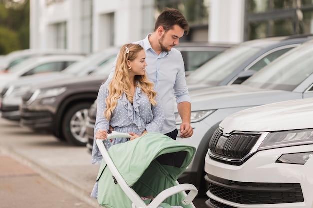 Glückliches Paar, das Autos betrachtet