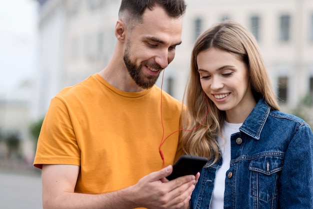 Glückliches paar, das ein handy betrachtet