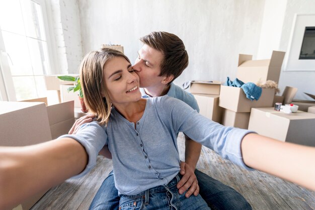 Glückliches Paar, das ein Selfie beim Packen nimmt, um ausziehen