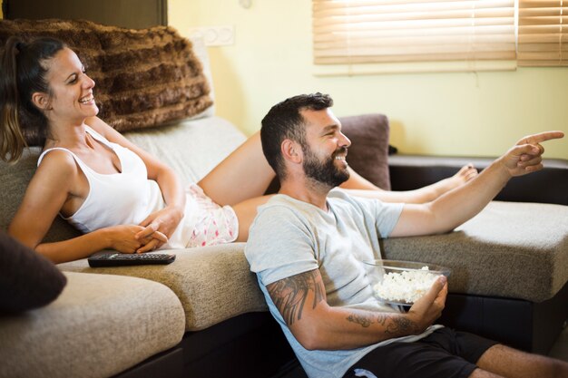 Glückliches Paar, das Film mit Popcorn genießt