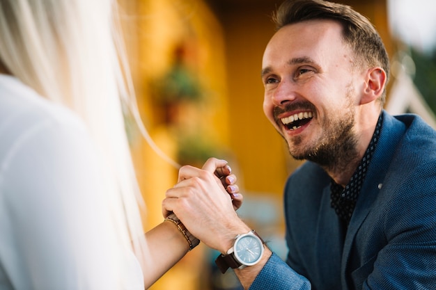 Glückliches Paar, das jede andere Hand hält