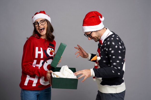 Glückliches Paar, das Weihnachtsgeschenk öffnet