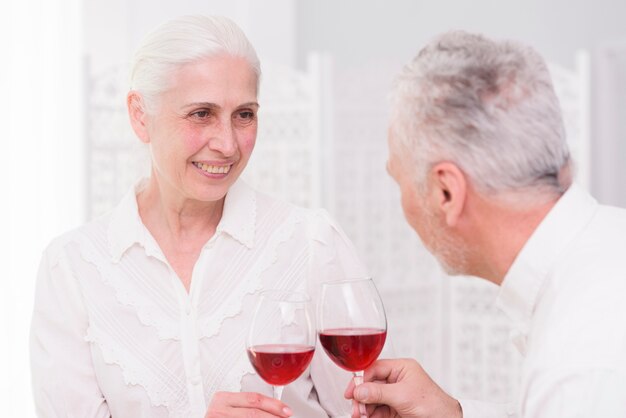 Glückliches Paar, das zusammen Gläser Wein zu Hause röstet