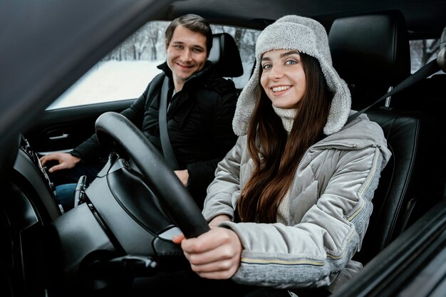 Glückliches Paar, das zusammen im Auto während eines Roadtrips aufwirft