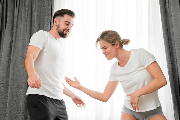 Glückliches Paar drinnen, das Karate im Spielmodus tut