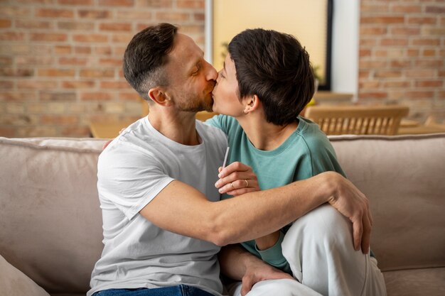 Glückliches Paar findet heraus, dass sie Eltern werden, basierend auf einem Schwangerschaftstest