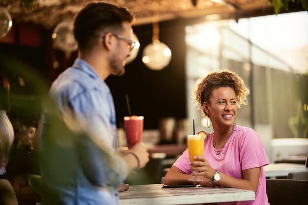 Glückliches Paar genießt in einer Bar und trinkt Cocktails Der Fokus liegt auf der Frau