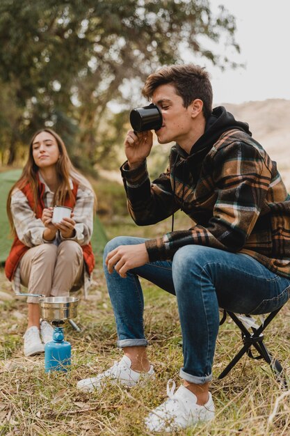 Glückliches Paar im Wald, das Kaffee trinkt