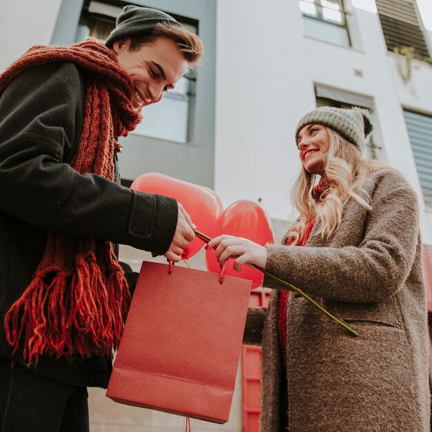 Glückliches Paar mit Ballonen und Geschenken