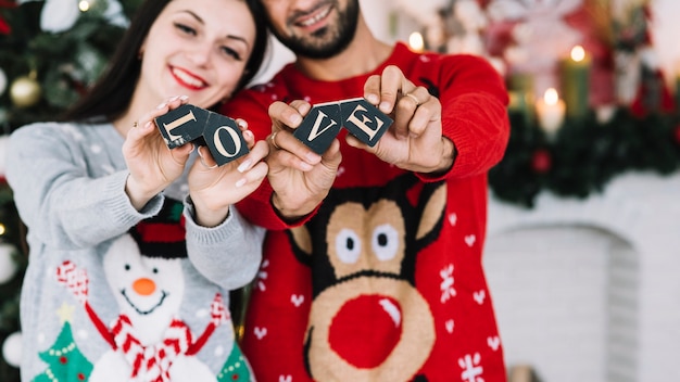 Kostenloses Foto glückliches paar mit liebesaufschrift