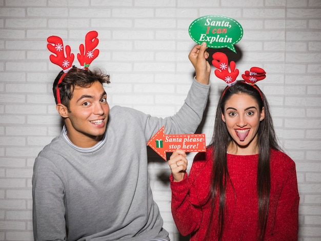 Glückliches Paar posiert mit Weihnachtsaufklebern