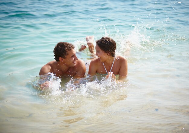 Glückliches Paar spielen im Wasser