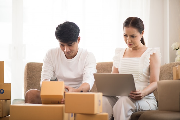 Glückliches Paar zu Hause im Büro mit Online-Geschäft, Online-Marketing und freiberuflicher Tätigkeit