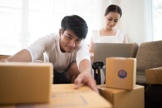 Glückliches Paar zu Hause im Büro mit Online-Geschäft, Online-Marketing und freiberuflicher Tätigkeit