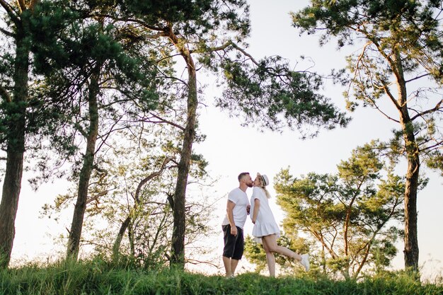 Glückliches Porträt des liebenden Paares auf einem Spaziergang im Park an einem sonnigen Tag.