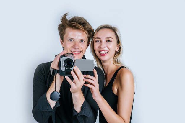 Glückliches Porträt von den Paaren, die Videokamera und Rekordclipvideo halten
