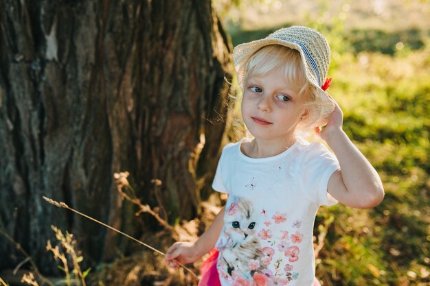 Glückliches schönes Kind auf dem großen Garten auf der Dämmerungszeit