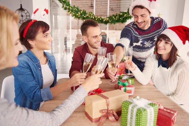 Glückliches Team, das an der Weihnachtsbüroparty anstößt