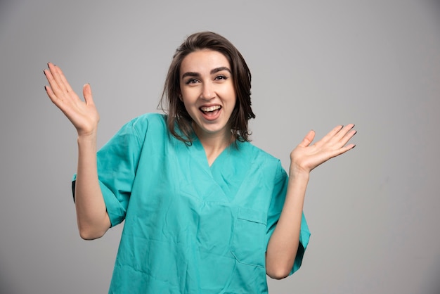 Glückliches weibliches Lachen auf grauem Hintergrund. Hochwertiges Foto